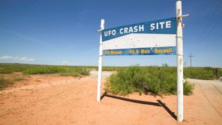 a sign in the desert that reads "ufo crash site, ufo museum 114 north main street, roswell"